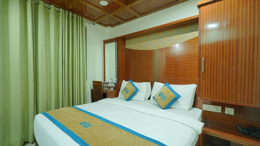 Deluxe room featuring a wooden headboard, a dressing table, a chair, and a mirror next to the bed at DLS Hotels The Rock Castle.
